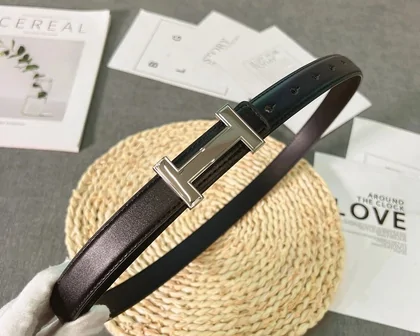 Black belt with a rectangular metal buckle on a straw mat