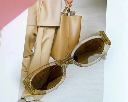 Brown translucent sunglasses beside a tan handbag