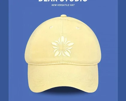 Pale yellow cap with a white flower motif on blue